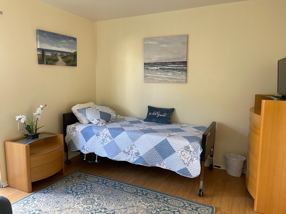 Furnished resident bedroom with adjustable bed and dresser