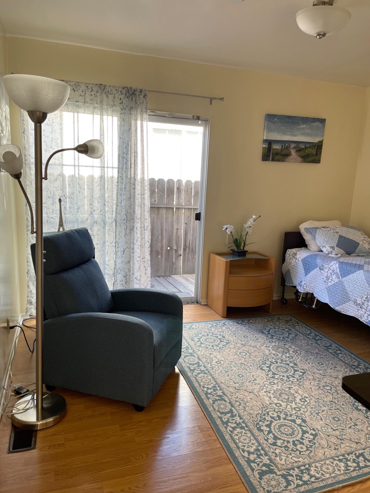 Private bedroom suite with blue armchair and sliding door to private deck