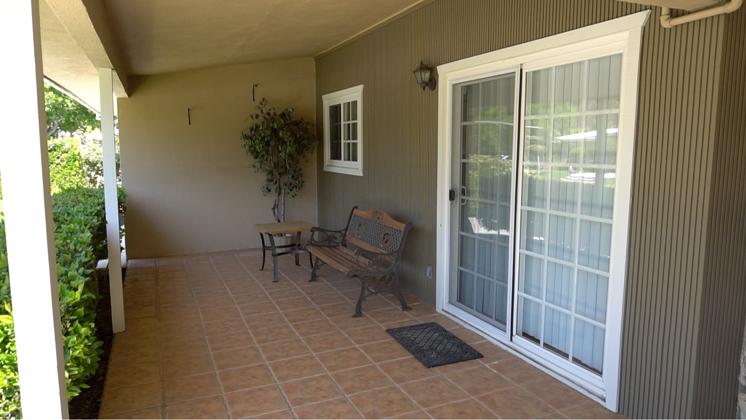 Covered front porch and garden bench at Woodland Hills