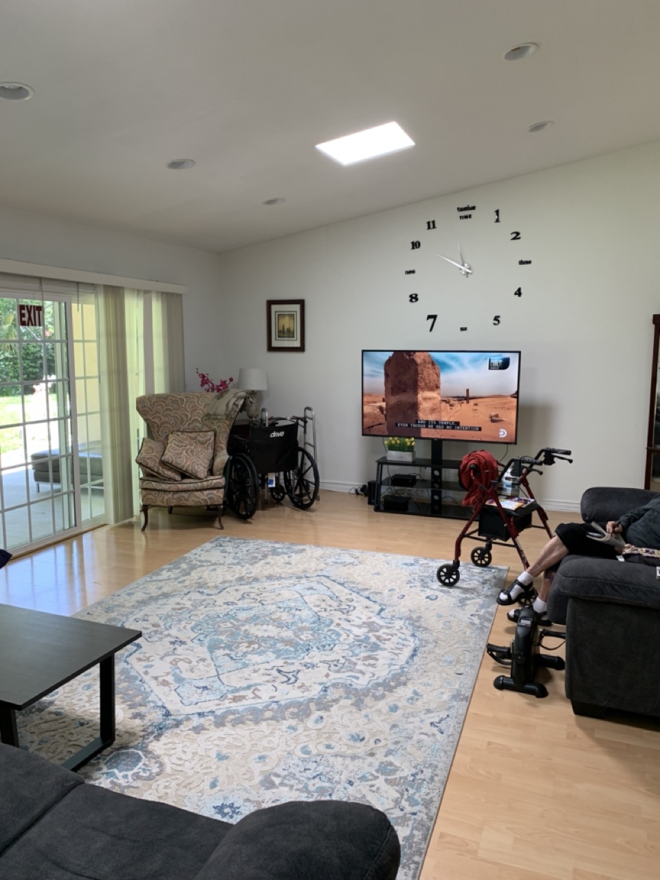 Bright common lounge with flat-screen TV, recliners and patio access