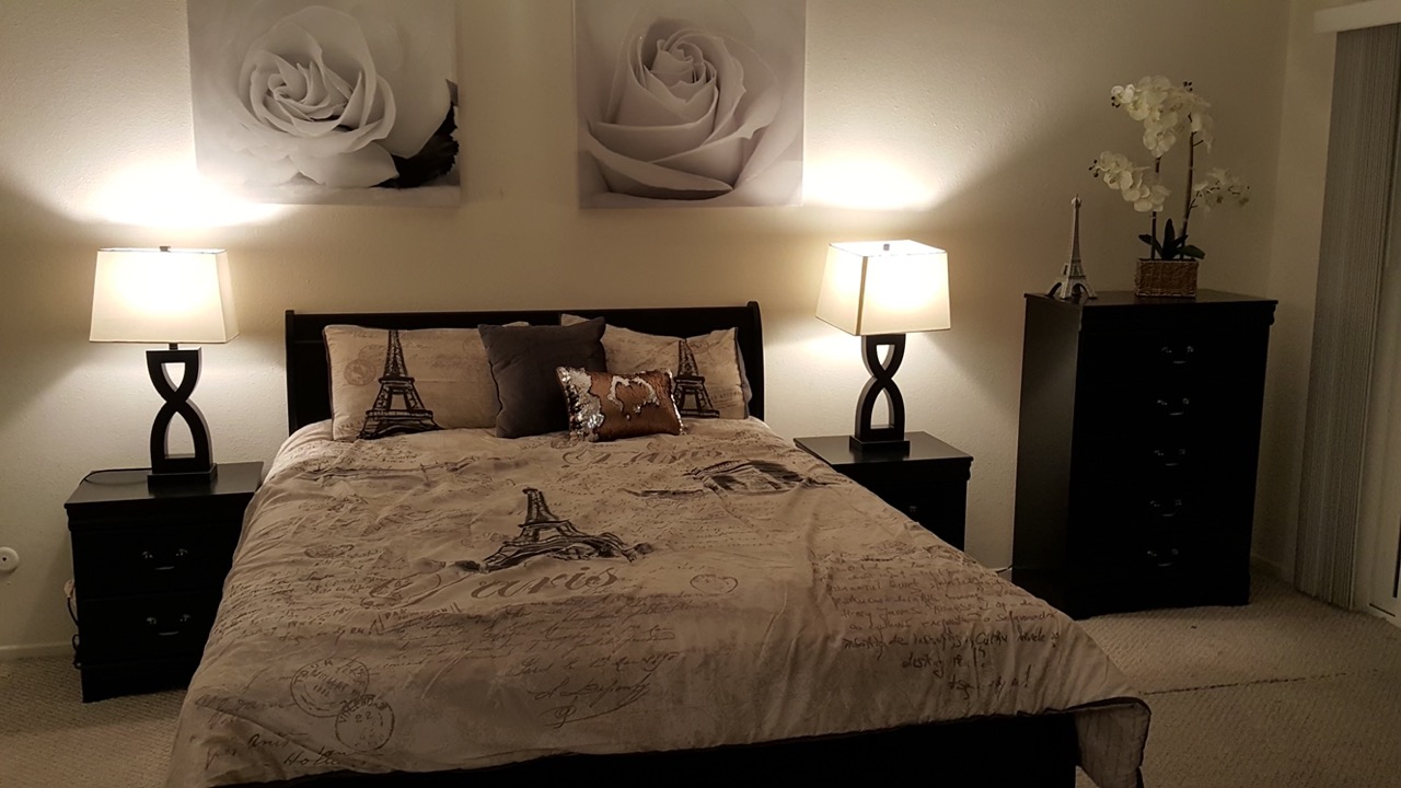 Comfortably furnished bedroom suite with bedside lamps and dresser
