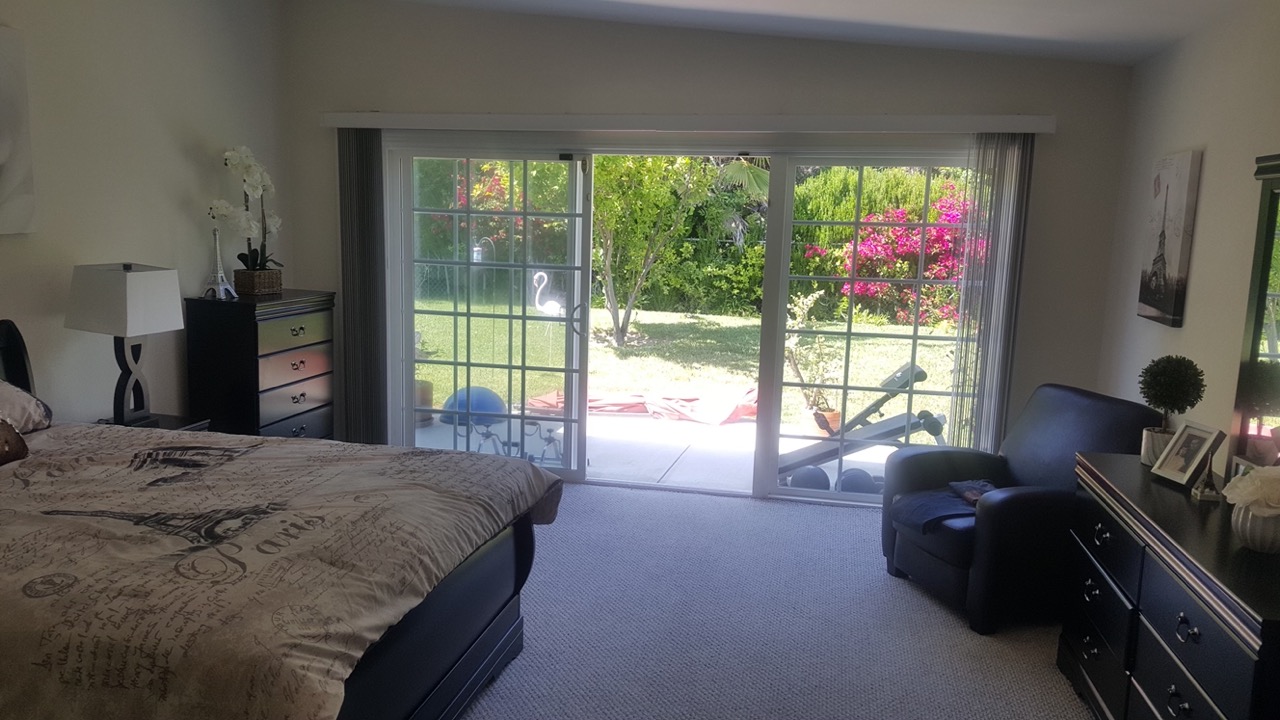 Resident bedroom with armchair and view into the backyard garden