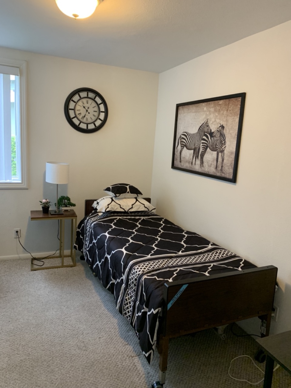 Furnished private resident bedroom with single bed, nightstand and window
