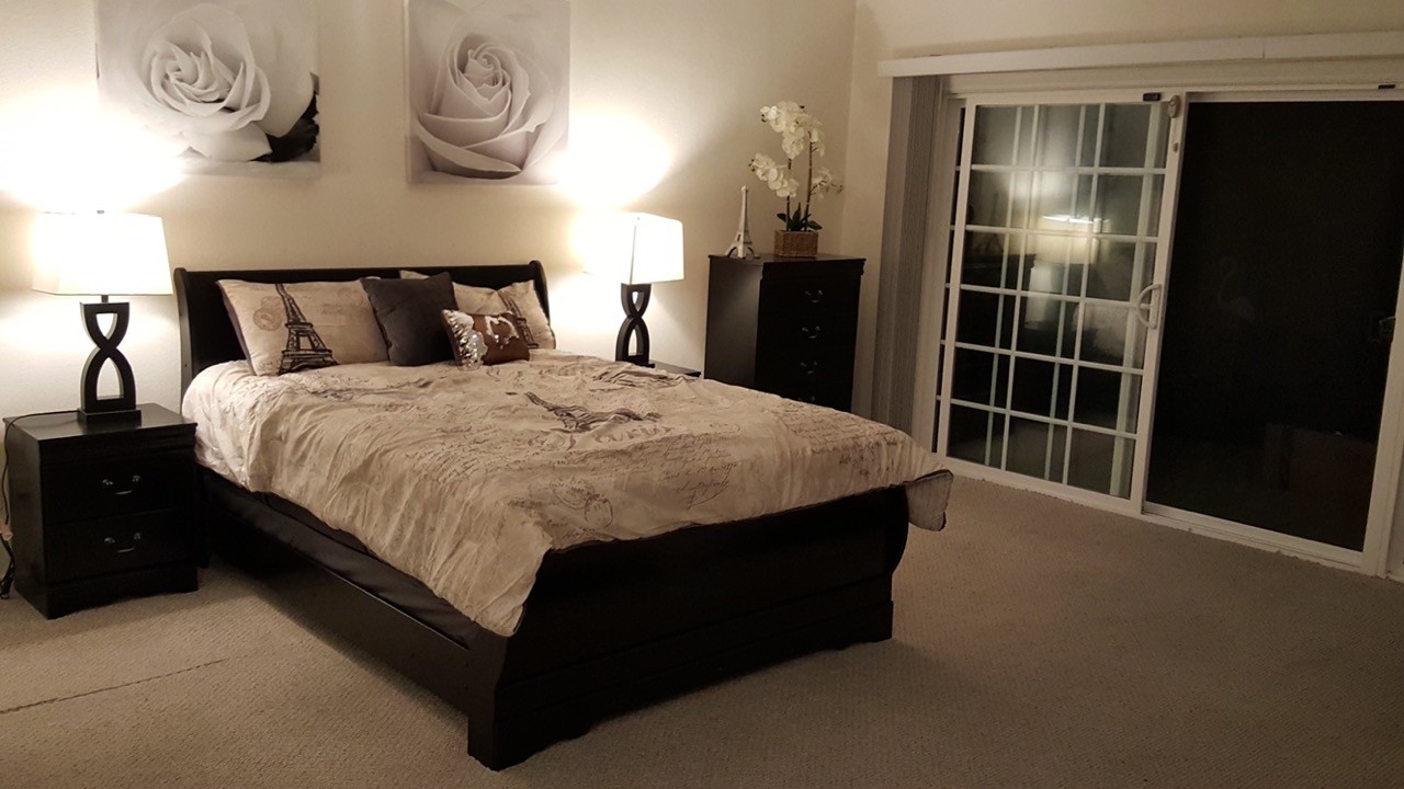 Spacious bedroom suite with queen bed and sliding door to patio